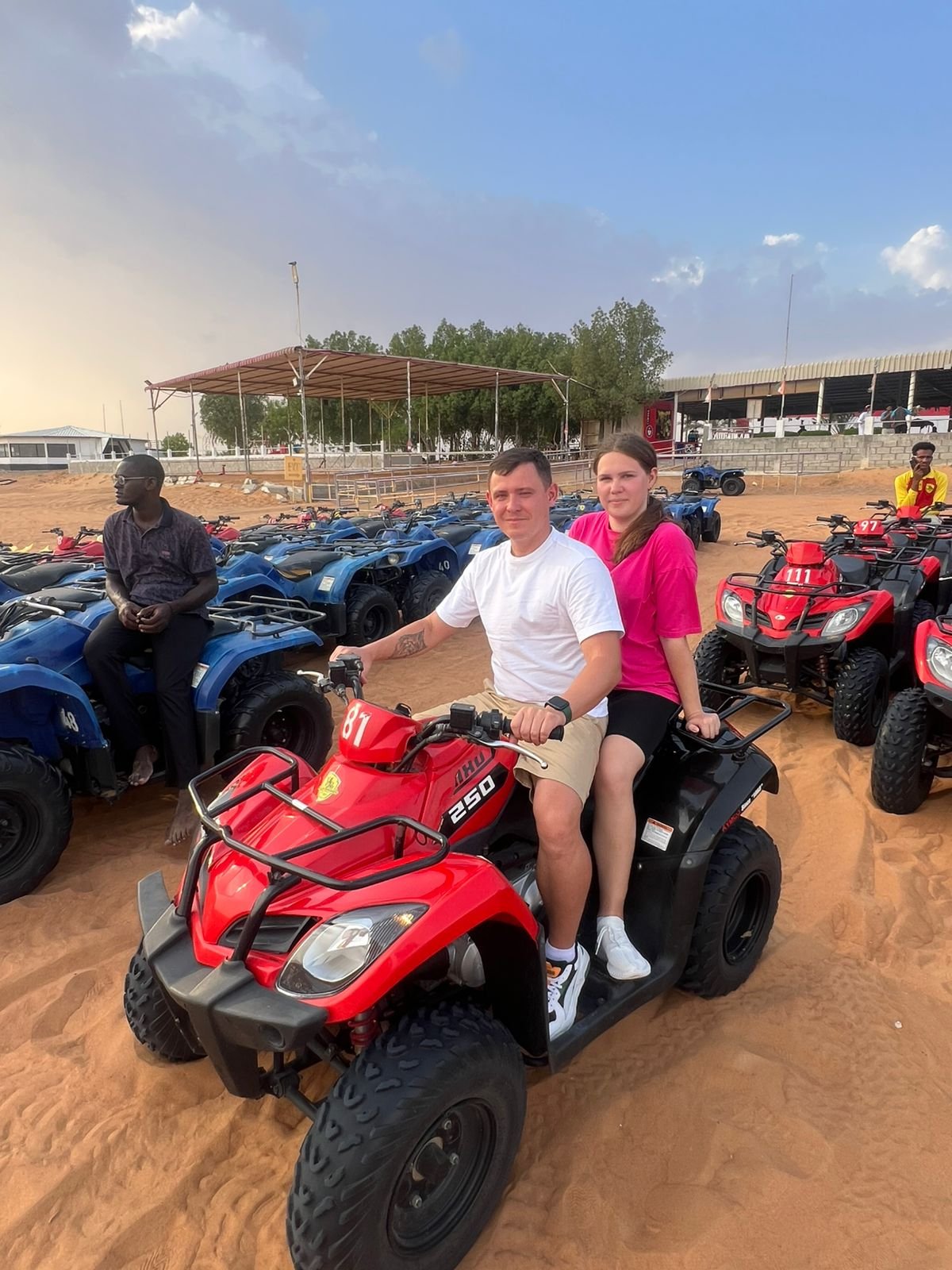 A person riding an ATV quad bike on a sand dune