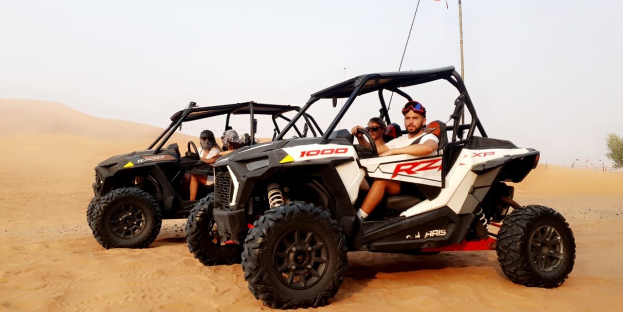 A red two-seater dune buggy in the desert